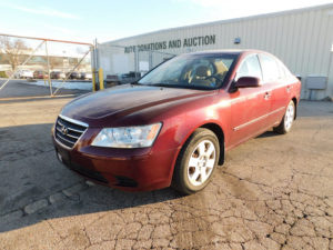 Front view of red 2009 Hyundai Sonata sedan at Goodwill Auto Auction