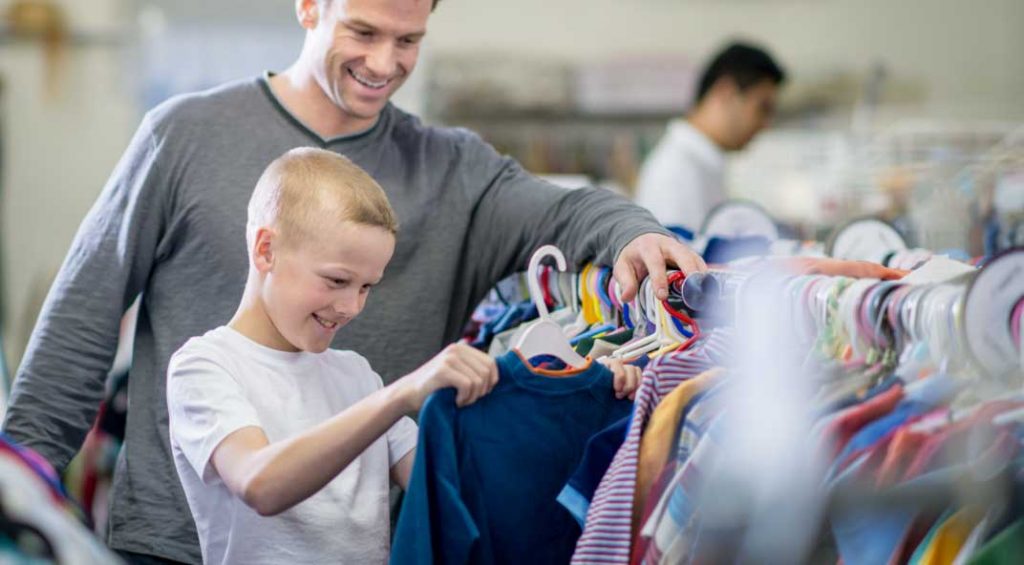 young boy and man shopping from a clothing rack