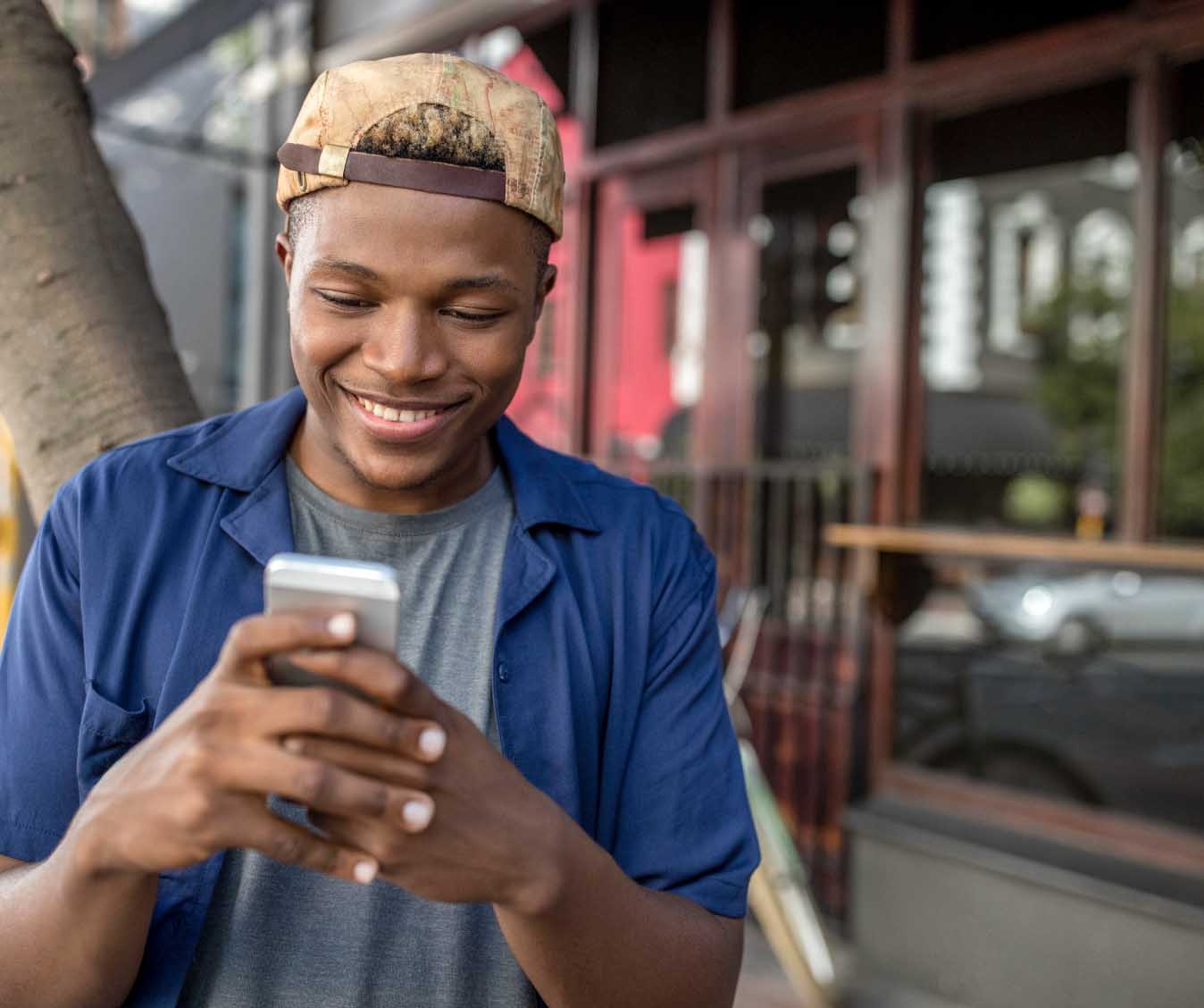 Man smiles while reading cell phone