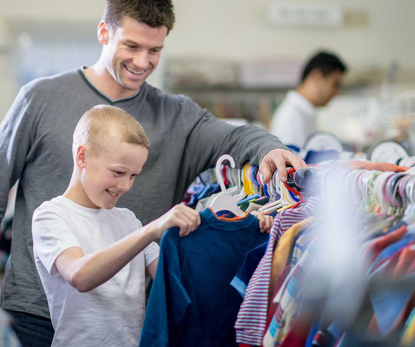 Man and son look through rack of clothes