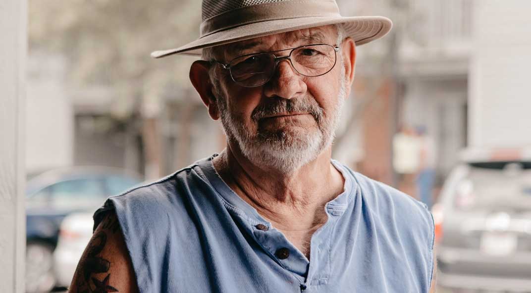 Elderly man in hat poses for camera