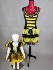Children's and adult bee halloween costumes on mannequins