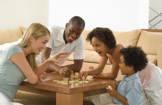 Family around a table playing a board game