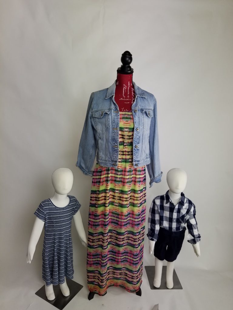 Adult-sized Mannequin with two child mannequins dressed in Goodwill clothing 