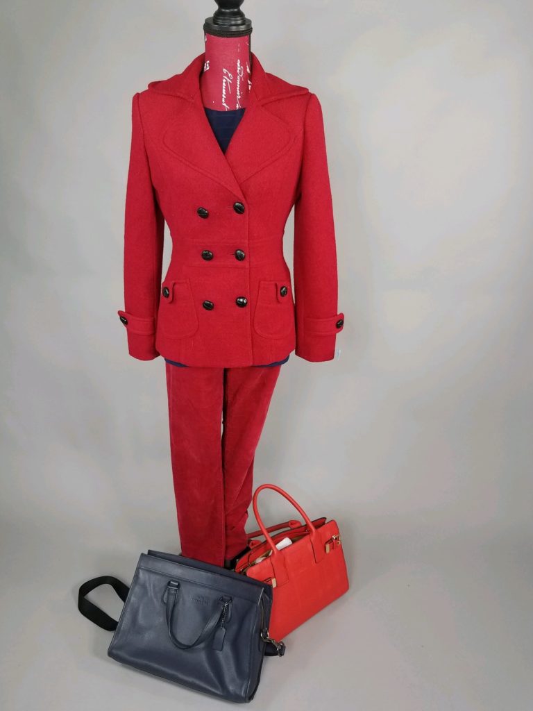 Mannequin dressed in red suit with black briefcase and red purse