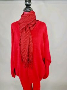 Mannequin dressed in red sweater with red scarf