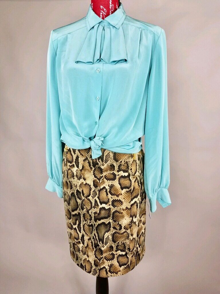 Mannequin dressed in blue blouse with snake skin pencil skirt
