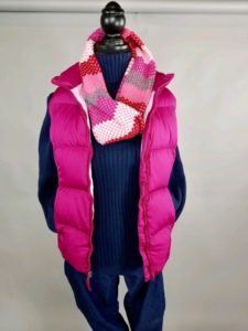 Mannequin dressed in pink vest with pink striped scarf