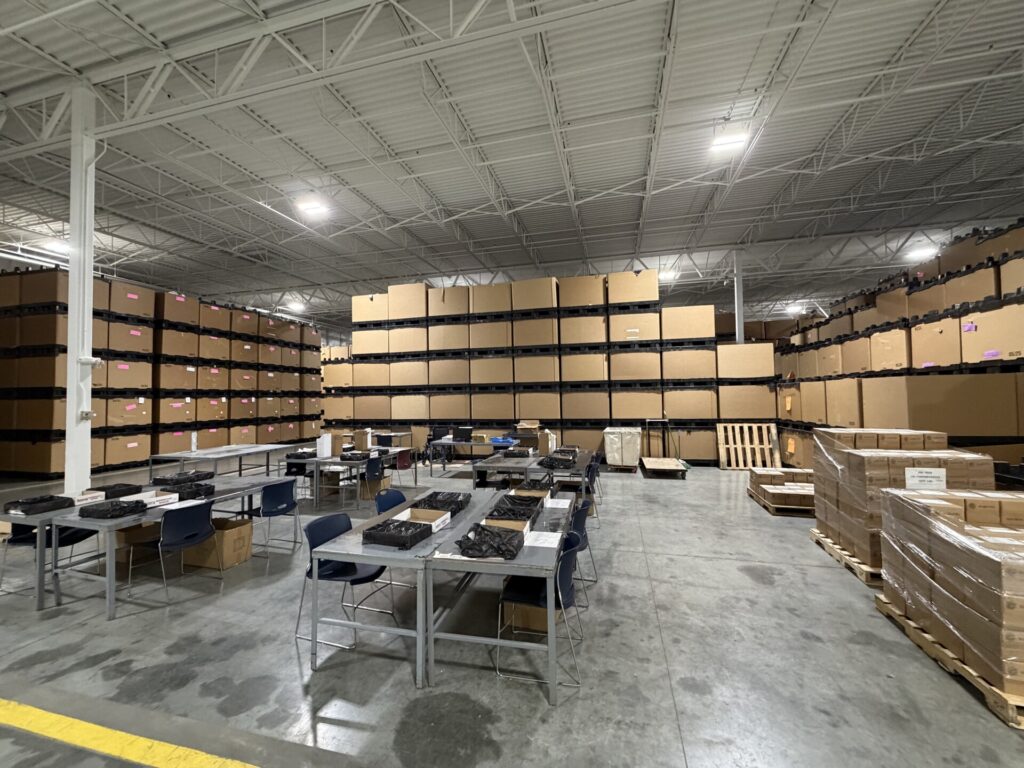 Large warehouse with stacked boxes and work tables