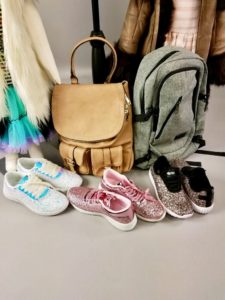 Display of backpacks and tennis shoes on floor