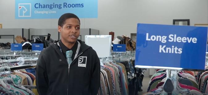 Store employee standing near long sleeve knits section