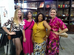 Fashion Designer Nikki Martin in gold surrounded by  models wearing her designs at 2016 show.