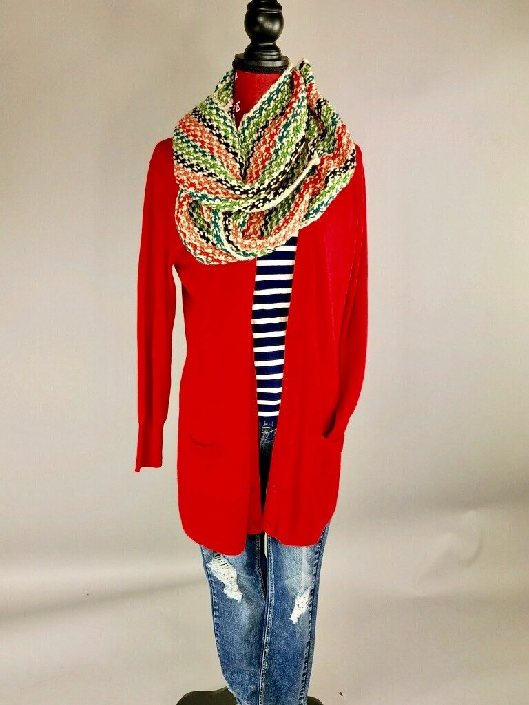 Mannequin dressed in jeans, striped shirt, red sweater, and green scarf 