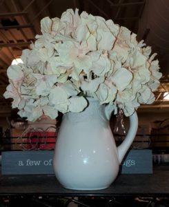 White vase filled with white flowers from Goodwill