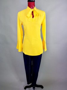 Mannequin dressed in yellow blouse with black slacks
