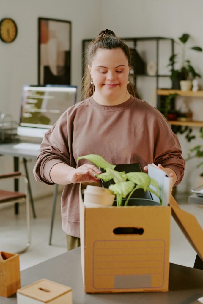 Woman packing office items into cardboard box