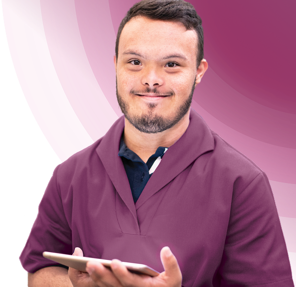 Smiling man in maroon scrubs holding tablet