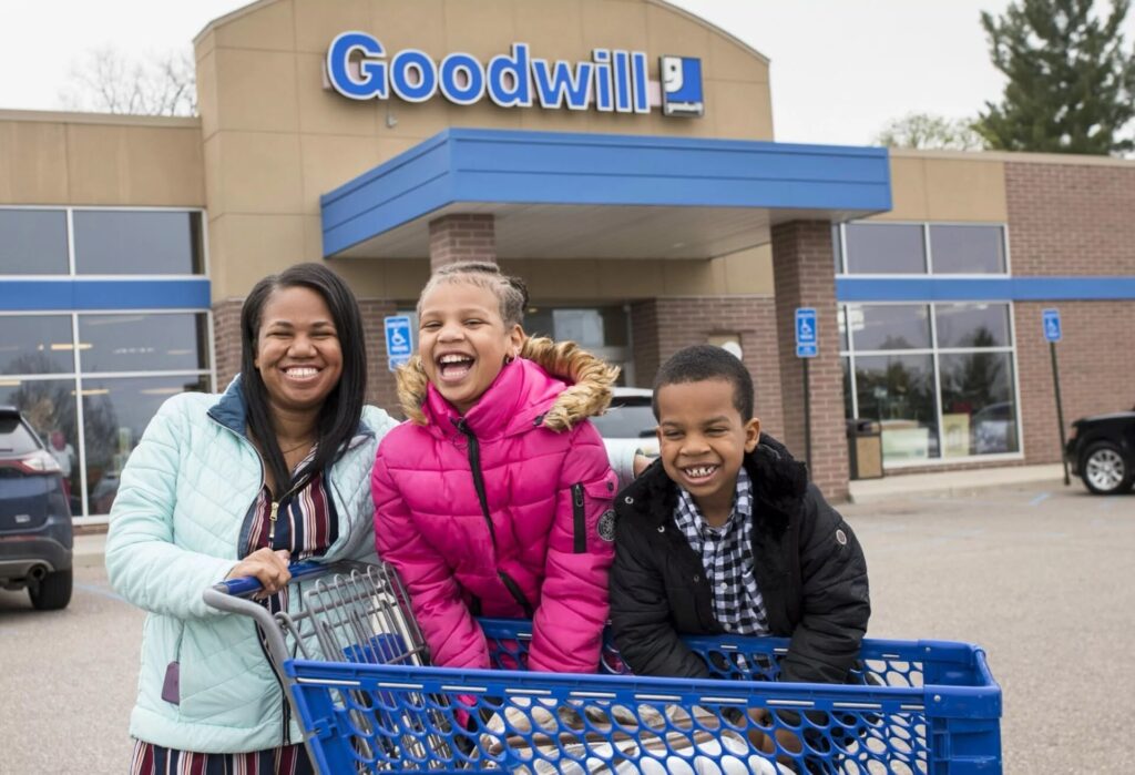Mother and children outside Goodwill store with cart