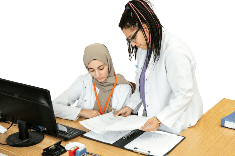 Two doctors reviewing paperwork at desk